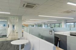 The LWCC office redesign features glass-walled private offices and low partitions topped with glass between workstations. The linear fixtures are by Lumato.