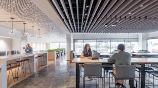 The company caf&eacute; features decorative pendant lighting from E. Kraemer over the bar tables and Tech Lighting over the booths. Track lighting is recessed within the ceiling baffles.