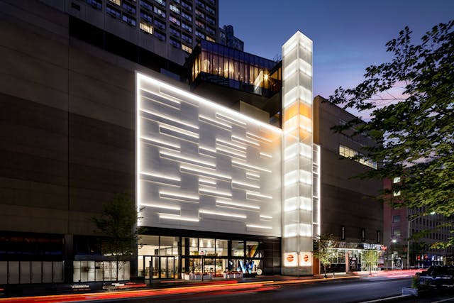 Fa&ccedil;ade panels in relief glow at night while a colorful elevator cab and luminous shaft act as a dynamic beacon for W Toronto.