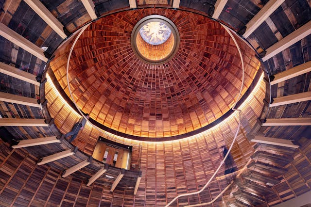 Short, straight LED luminaires encircle the interior of the handcrafted dome and copper skylight in the atrium lobby.
