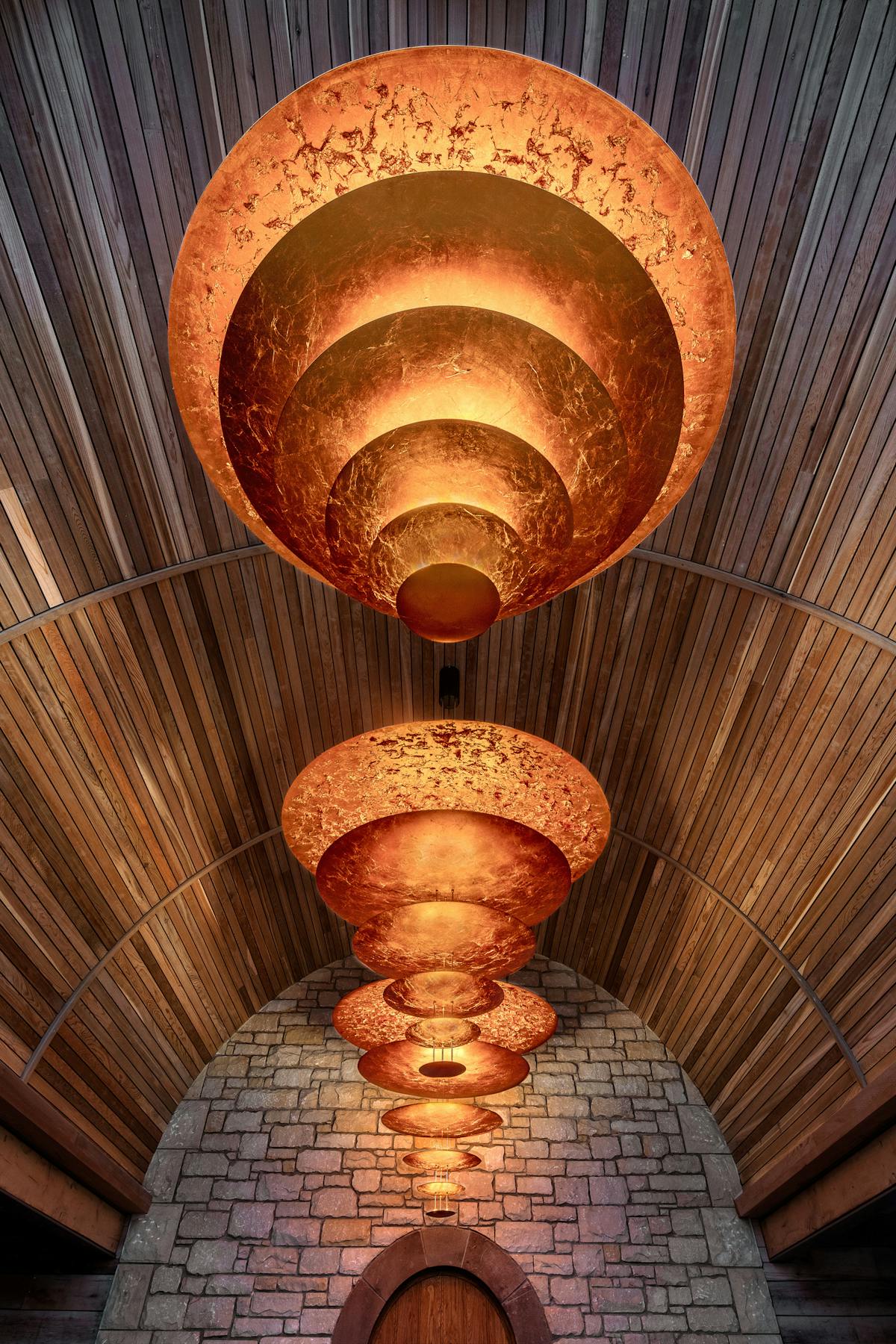 Three multi-tier copper chandeliers illuminate the event space and recall the copper stills.