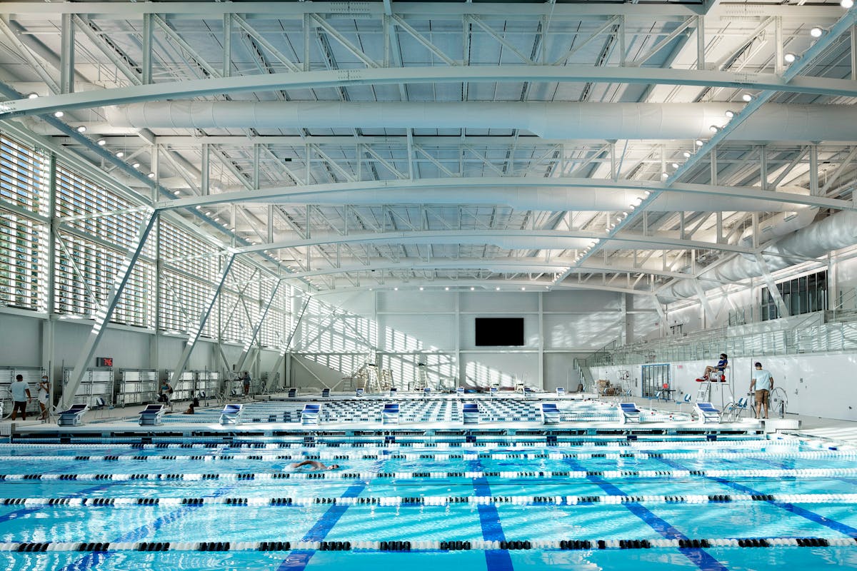 A custom solution prevents the natatorium&rsquo;s overhead lights from causing glare for swimmers while remaining accessible for maintenance.