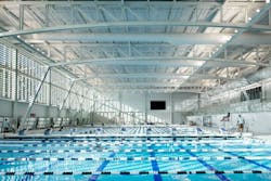 A custom solution prevents the natatorium&rsquo;s overhead lights from causing glare for swimmers while remaining accessible for maintenance.