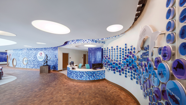 A curved mosaic feature wall is illuminated with LED PAR20 lamps in the children’s hospital lobby.